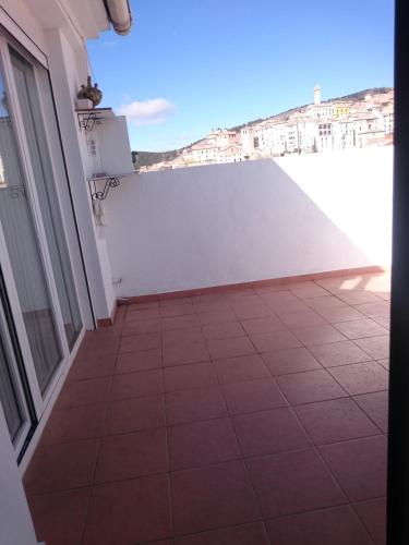 einen Balkon mit Fliesenboden und einer weißen Wand in der Unterkunft La terraza de Maxi Casa completa in Cuenca