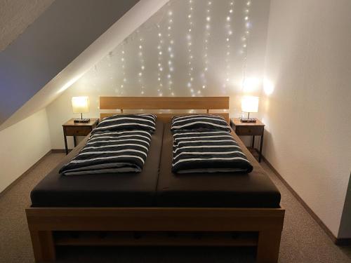 a bedroom with two beds with lights on the wall at Gut und Günstig in Leipzig - zentrumsnah - inkl Fahrräder, Netflix und Tiefgaragenstellplatz in Leipzig