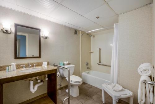 a bathroom with a toilet and a sink and a tub at Exton Hotel and Conference Center in Exton