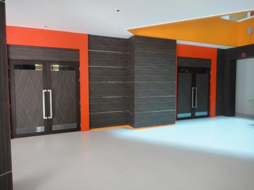 a large room with wooden doors and orange accents at Twin Hotel in Phuket