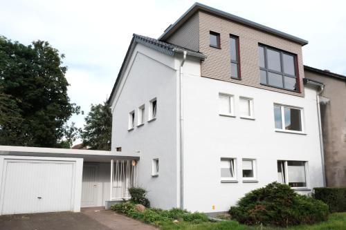 a white house with a garage at Ferienwohnung Speldorf in Mülheim an der Ruhr