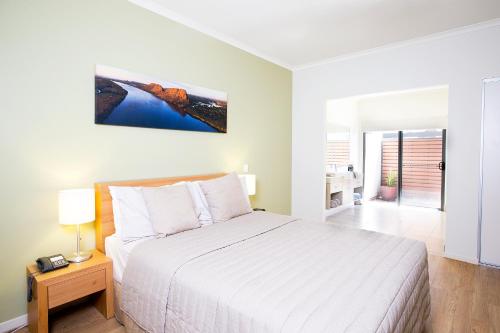a hotel room with a bed and a television at Freshwater East Kimberley Apartments in Kununurra