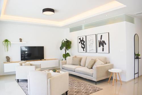 a living room with a couch and a tv at New Build Apartment on Beautiful Modern Complex in Rojales