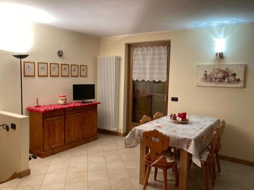 een eetkamer met een tafel en een televisie bij Casa Lina S. Pietro in San Pietro