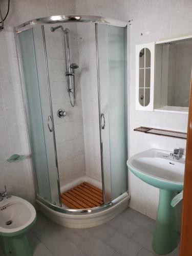 uma casa de banho com um chuveiro e um lavatório. em Villa cecilia em Mattinata
