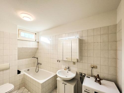 a white bathroom with a sink and a toilet at Über den Dächern der Löbervorstadt in Erfurt