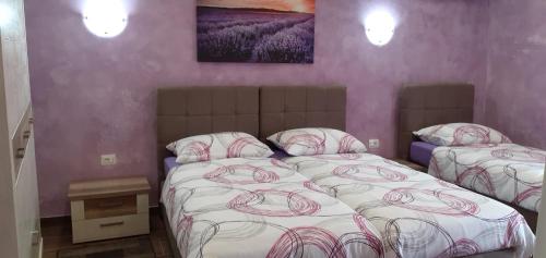 2 camas individuales en un dormitorio con paredes moradas en Apartman Miljenka en Pazin