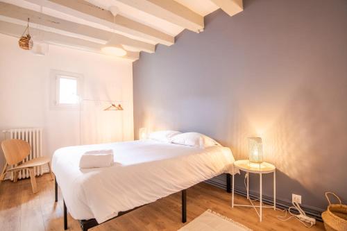 a bedroom with a large white bed and a table at La Maison Lamartine Havre de paix dans le centre de Tours in Tours