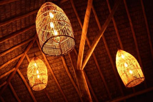 three lights hanging from the ceiling of a building at Pousada Vila Camurim in Atins