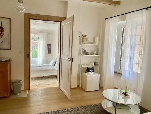 ein Wohnzimmer mit einer Tür, die zu einem Schlafzimmer führt in der Unterkunft Beautiful studio in a villa from 18th century in Thun