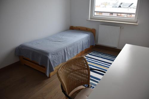 um quarto com uma cama, uma cadeira e uma janela em Uroczy apartament z widokiem i darmowym parkingiem em Poznań