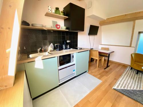 a small kitchen with a sink and a table at Ogma, Studio coquet au calme in Caen