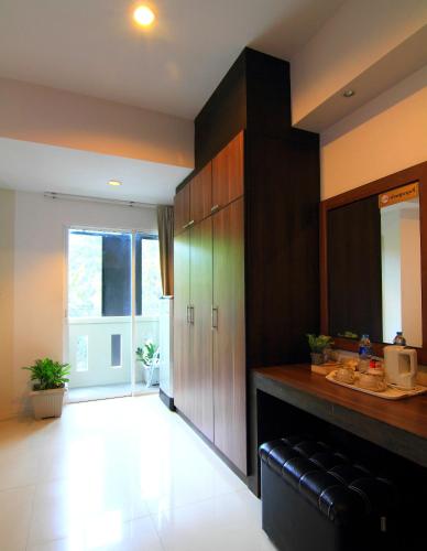 a kitchen with wooden cabinets and a sink in it at Cool Residence Hotel in Phuket Town