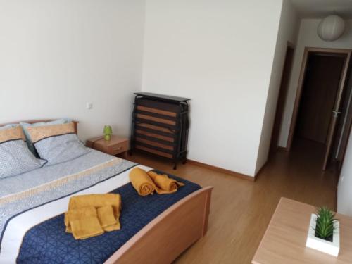 ein Schlafzimmer mit einem Bett mit gelben Handtüchern darauf in der Unterkunft Sao Martinho Place in São Martinho do Porto