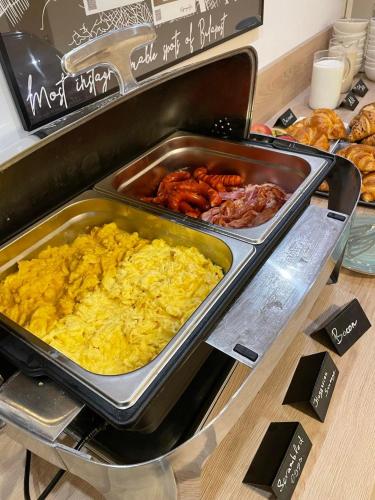 a breakfast buffet with scrambled eggs and other food at KViHotel Budapest - the smart hotel in Budapest