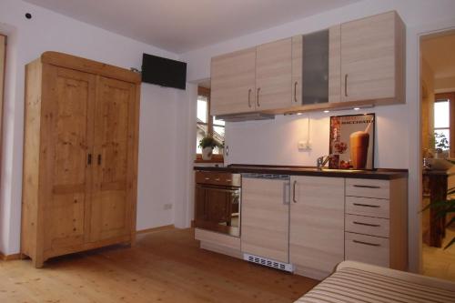 a kitchen with wooden cabinets and a wooden door at Ferienwohnung mit wundervollen Bergblick in Lenggries