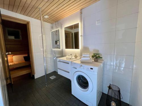 ein Badezimmer mit einer Waschmaschine und einem Waschbecken in der Unterkunft Spacious City Center Apt - Sauna - Self Check in in Rovaniemi