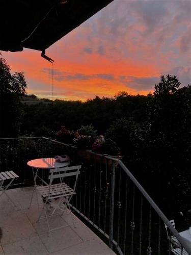 a table and chairs on a balcony with a sunset at PIGGIOLO in Rocca Malatina