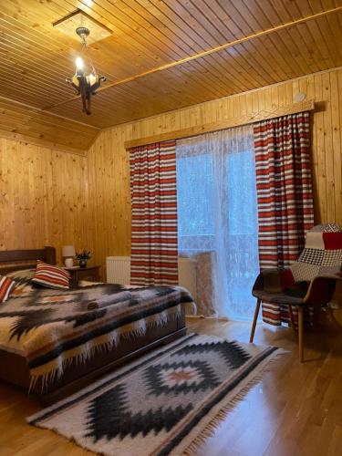 a bedroom with a large bed and a large window at Світанкове сяйво in Yaremche