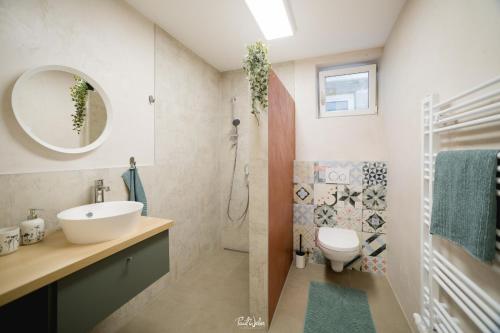 W łazience znajduje się umywalka, toaleta i lustro. w obiekcie Apartment Enarina in Telfs w mieście Telfs