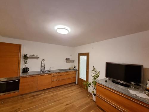 a large kitchen with wooden floors and a flat screen tv at Apartment Enarina in Telfs in Telfs