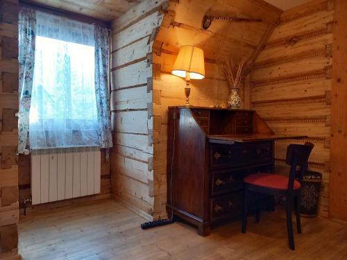 an office in a log cabin with a desk and a window at Good Bye Lenin Hostel Zakopane in Zakopane