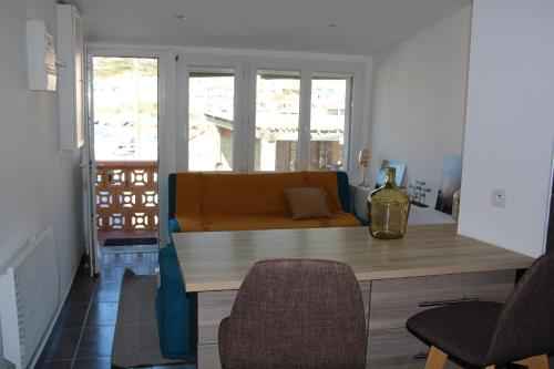 un salon avec une table et un canapé dans l'établissement Charmant Cabanon aux Goudes à Marseille avec vue mer, à Marseille