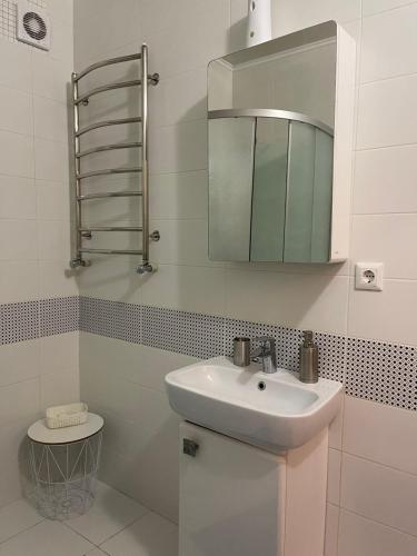 uma casa de banho branca com um lavatório e um espelho em Світанкове сяйво em Yaremche
