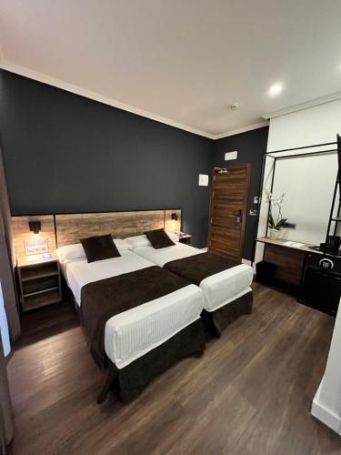 
a hotel room with a bed, chair, and nightstand at Hotel BH San Francisco in Alicante
