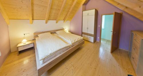 ein Schlafzimmer mit einem großen Bett und Holzboden in der Unterkunft Ferienhaus Quelle in Loßburg