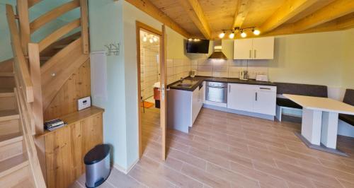 eine Küche mit weißen Schränken und Holzböden in der Unterkunft Ferienhaus Quelle in Loßburg