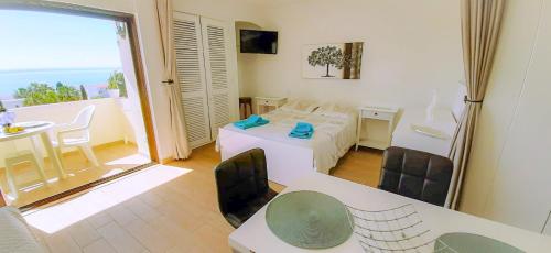 a room with a table and chairs and a balcony at Ocean View - Fantástico Studio em Albufeira in Albufeira