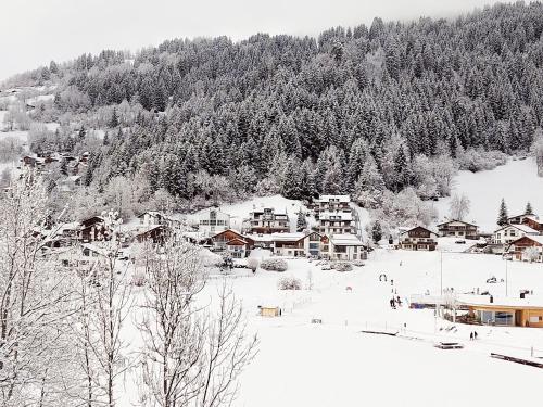 a snow covered village with houses and trees at LAAX Central Holiday Apartment with Pool & Sauna in Laax