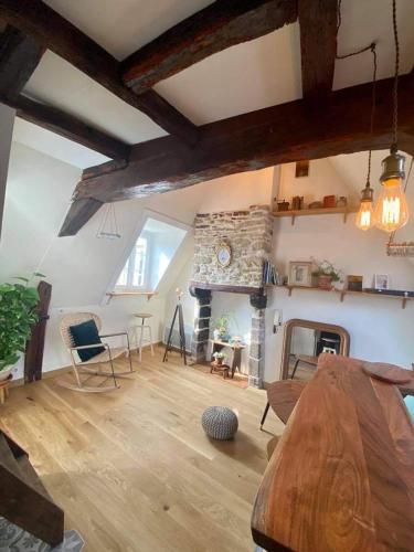 - un salon avec une table en bois et une cheminée en pierre dans l'établissement Bienvenue à Indra, à Vannes
