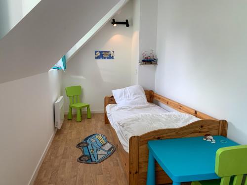 - une petite chambre avec un lit et une table bleue dans l'établissement Le 552 en Baie - Gîte 4 à 7 personnes avec parking, à Saint-Valery-sur-Somme