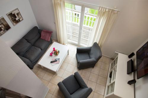 a living room with a couch and chairs and a table at Pippi´s Ostseetraum in Sierksdorf