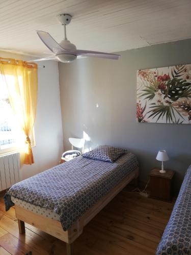 une chambre avec un lit et un ventilateur de plafond dans l'établissement La Terrasse, à Gignac