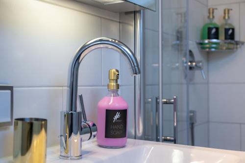 a bottle of pink soap sitting next to a sink at Ferienwohnung #TIMEOUT in Pfronten