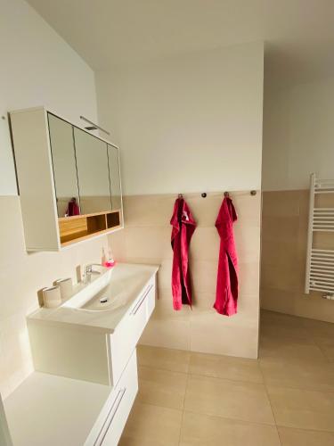 a white bathroom with a sink and a mirror at Fewo unweit Warnemünde Sobierajczyk in Markgrafenheide in Rostock