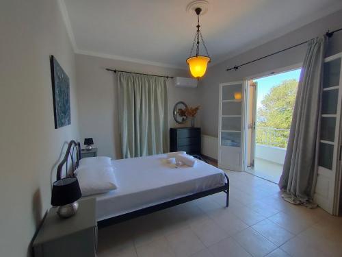 a bedroom with a bed and a large window at Villa Southern Comfort in Lefkimmi