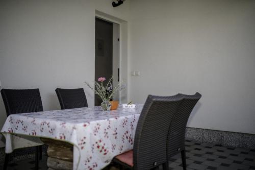 a table with a table cloth with a vase of flowers on it at Apartment in Lopar with Terrace, Air conditioning, WIFI, Dishwasher (4612-1) in Lopar