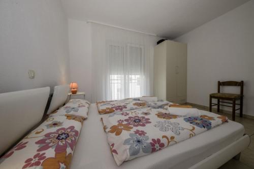a bedroom with two beds with floral pillows at Apartment in Lopar with Terrace, Air conditioning, Wi-Fi (4612-3) in Lopar