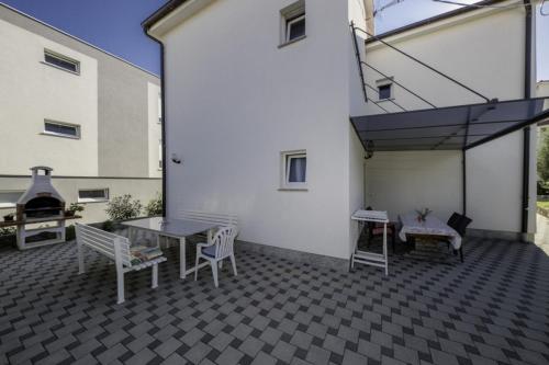 a patio with a table and chairs and a building at Apartment in Lopar with Terrace, Air conditioning, WIFI, Dishwasher (4612-1) in Lopar