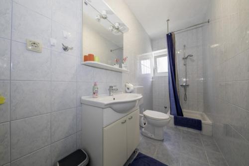 a bathroom with a sink and a toilet and a shower at Apartment in Lopar with Terrace, Air conditioning, Wi-Fi, Dishwasher (4612-2) in Lopar
