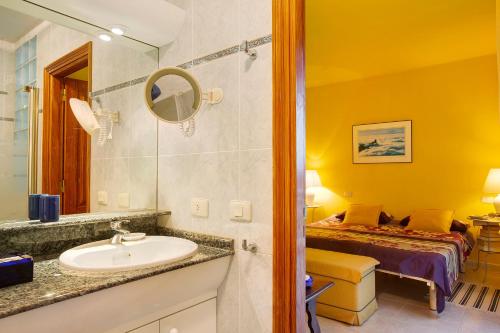 een badkamer met een wastafel en een bed in een kamer bij Vcv Villa Magua in Santa Brígida
