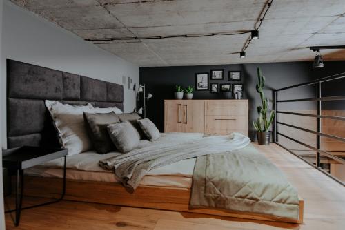 a bedroom with a large bed and black walls at Apartament Loft z Antresolami in Zamość