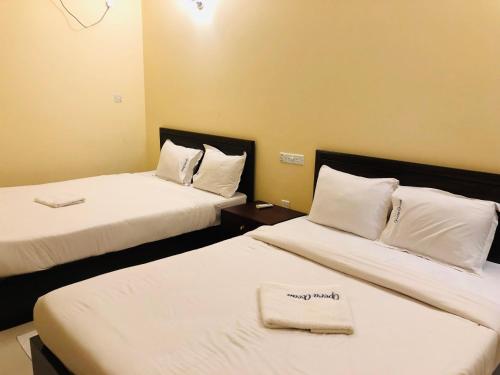 um quarto de hotel com duas camas com lençóis brancos em Hotel Opera Ocean em Cox's Bazar