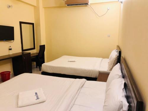 um quarto de hospital com duas camas e um espelho em Hotel Opera Ocean em Cox's Bazar