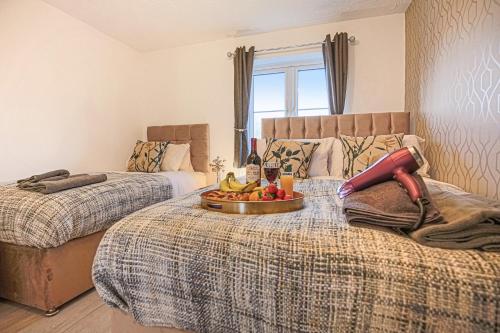 a bedroom with two beds with a tray of fruit on the bed at COSY 3 BED HOUSE to BICESTER OUTLET for BIG GROUP by Platinum Key Properties in Bicester