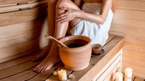 a woman is sitting in a sauna at Suite Petite -Nice - SPA-JACUZZI - MASSAGE- SAUNA - 4 SAISONS - Piscine Chauffée Toute l'année - POOL VIEW- Heated Pool 800m city centre Nyons in Nyons